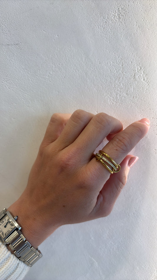 Hand wearing a gold ring on a light gray background